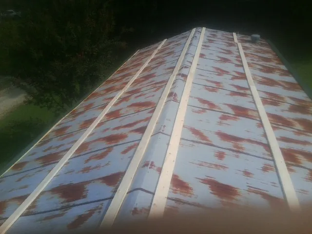 Rusted metal roof panels with new wood purlins before replacement — Storm Damage Roof Repair in Saint Paul by Roofing Brothers